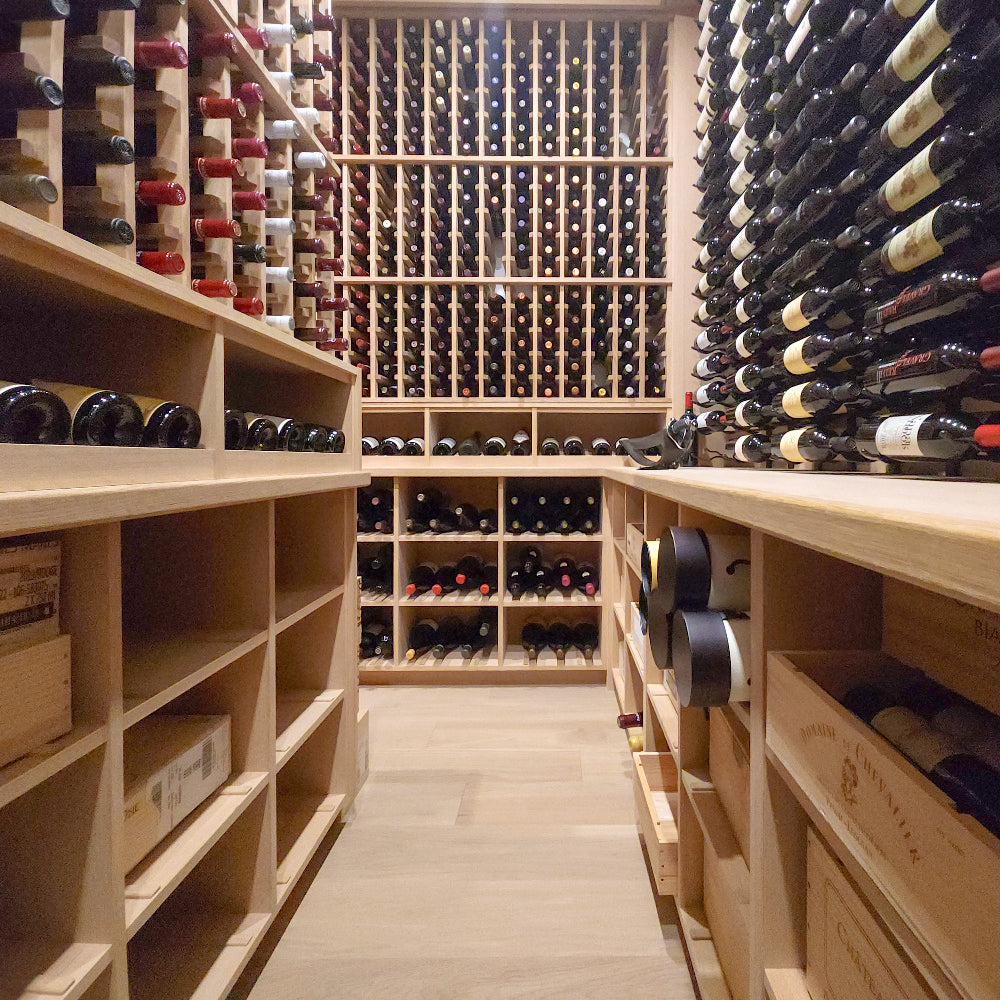 Wooden wine cellar with shelves filled with wine bottles.