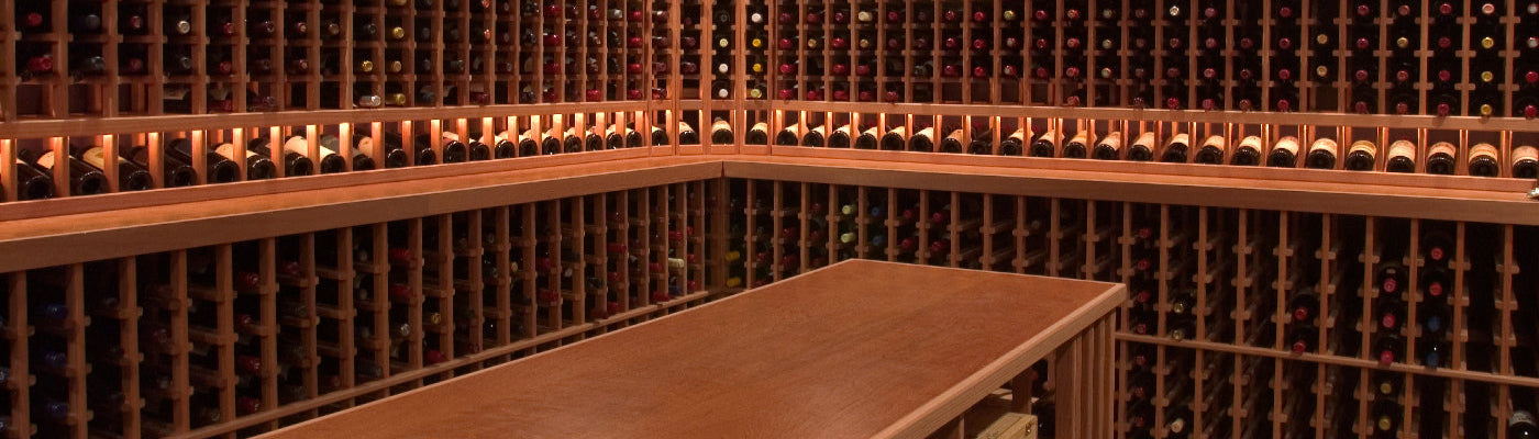 Wine cellar with wooden shelves filled with wine bottles.