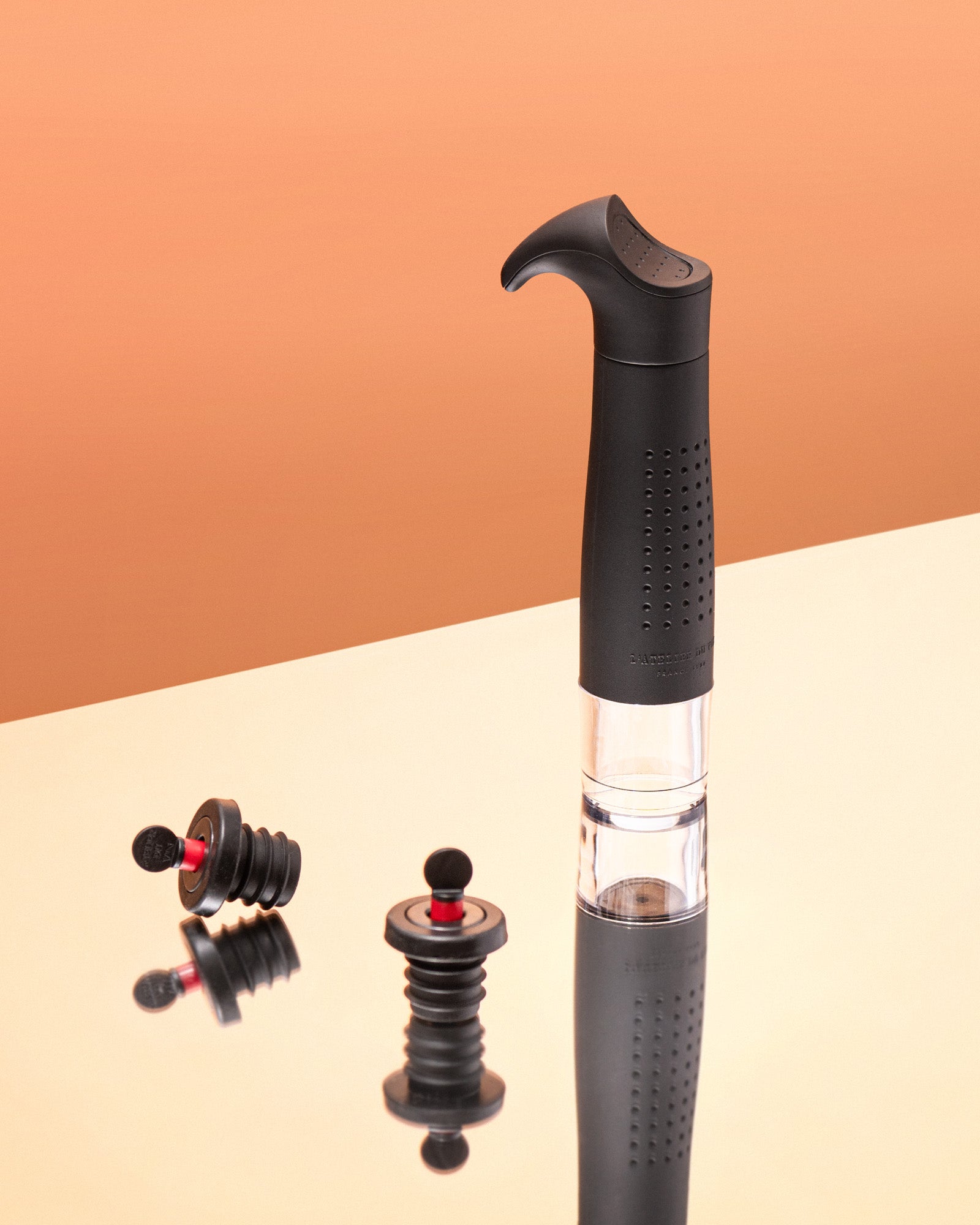 Black wine aerator with two additional nozzles on a beige and brown gradient background