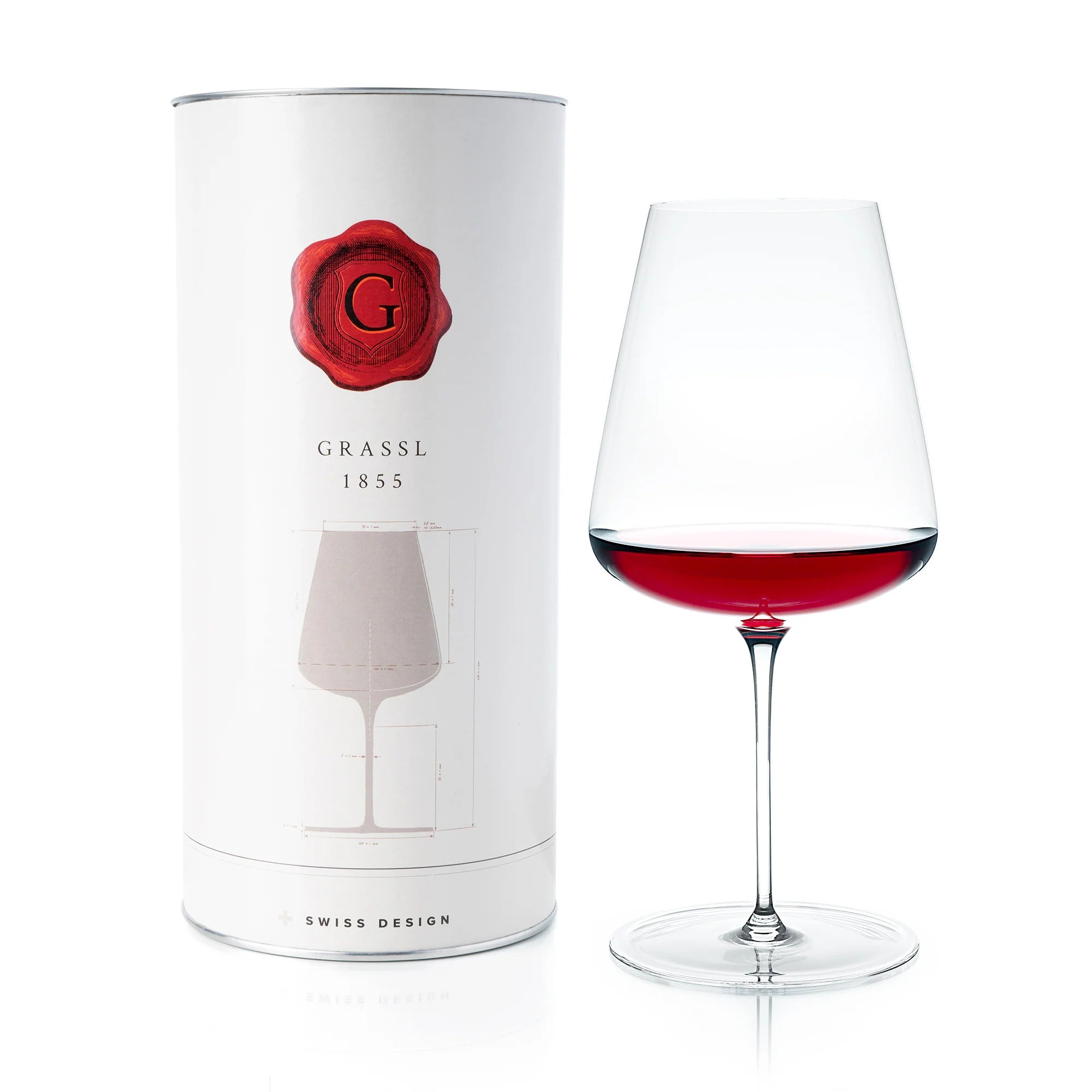 Wine glass with red wine next to a Grassl branded packaging tube on a white background