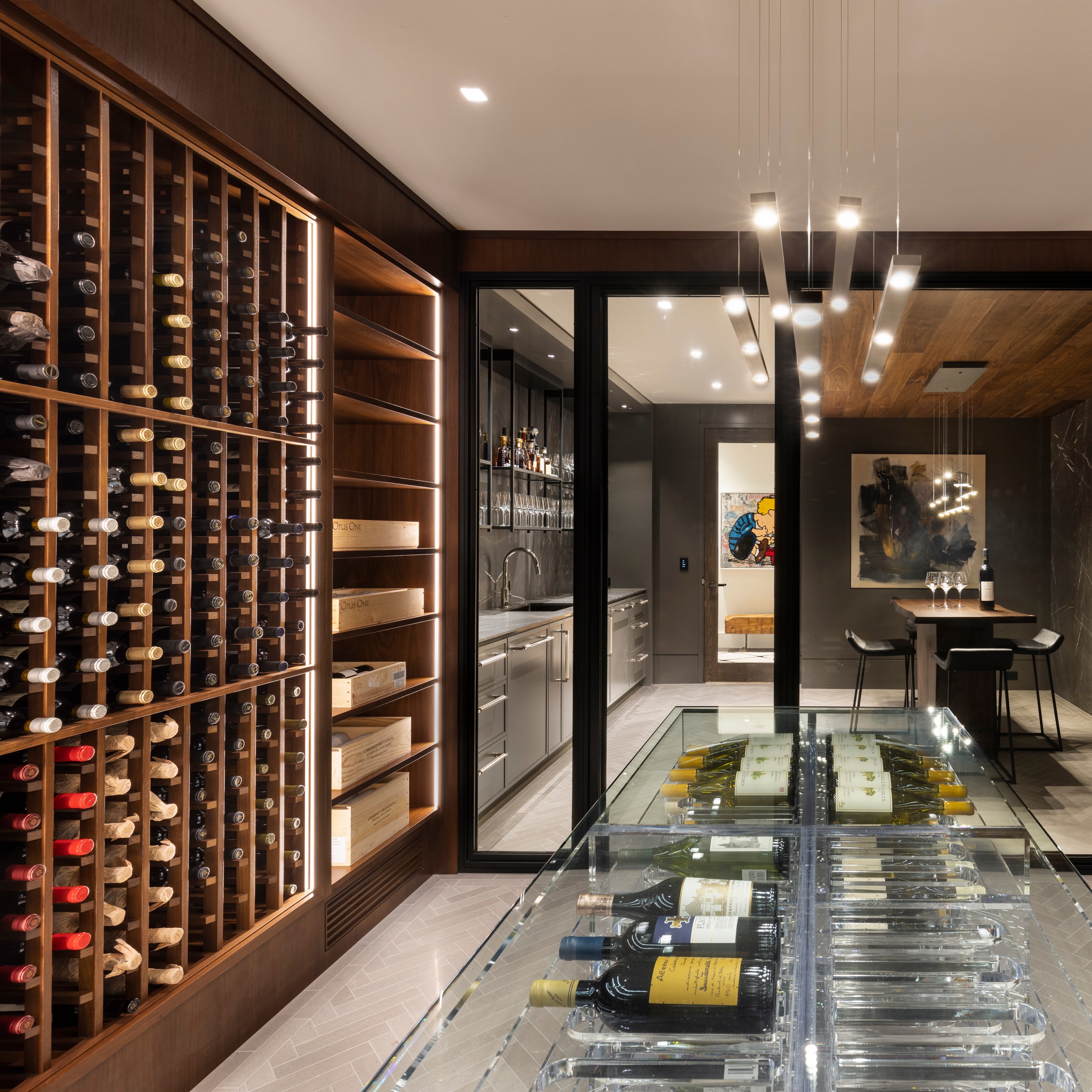 Modern wine cellar with wooden shelves and a glass display case.