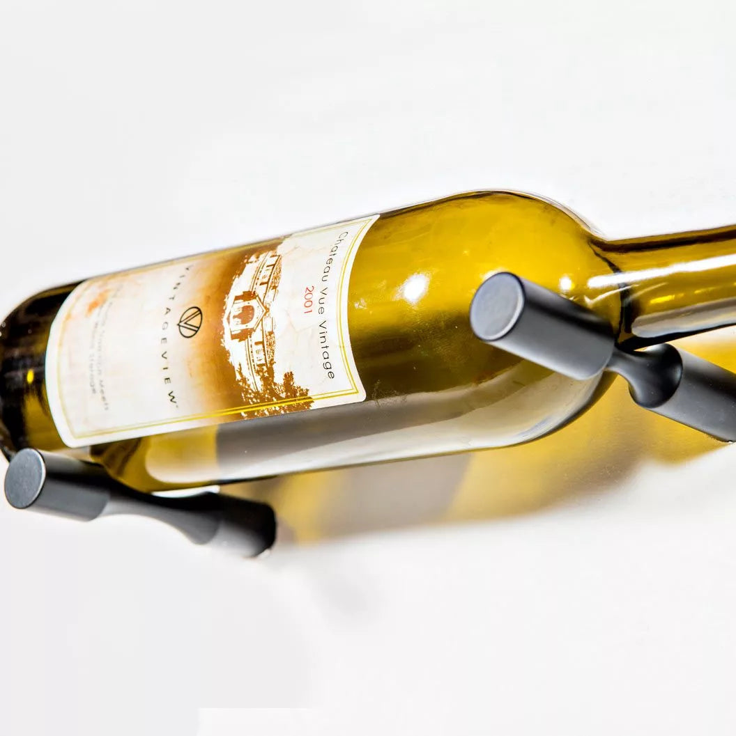 Wine bottle held by a metal bottle holder on a white background