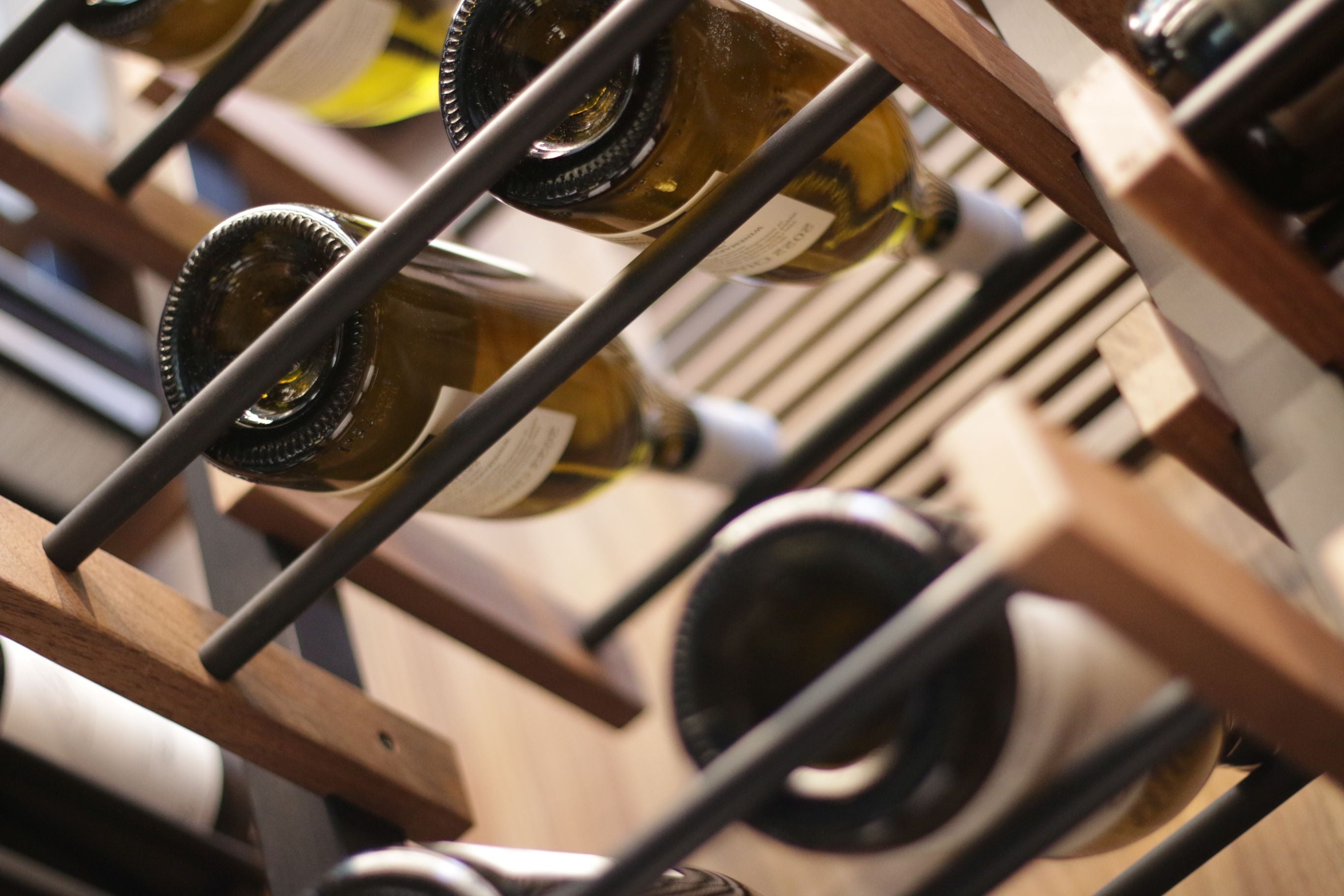 Wine bottles arranged on a wooden  Premier CRU rack with blurred background