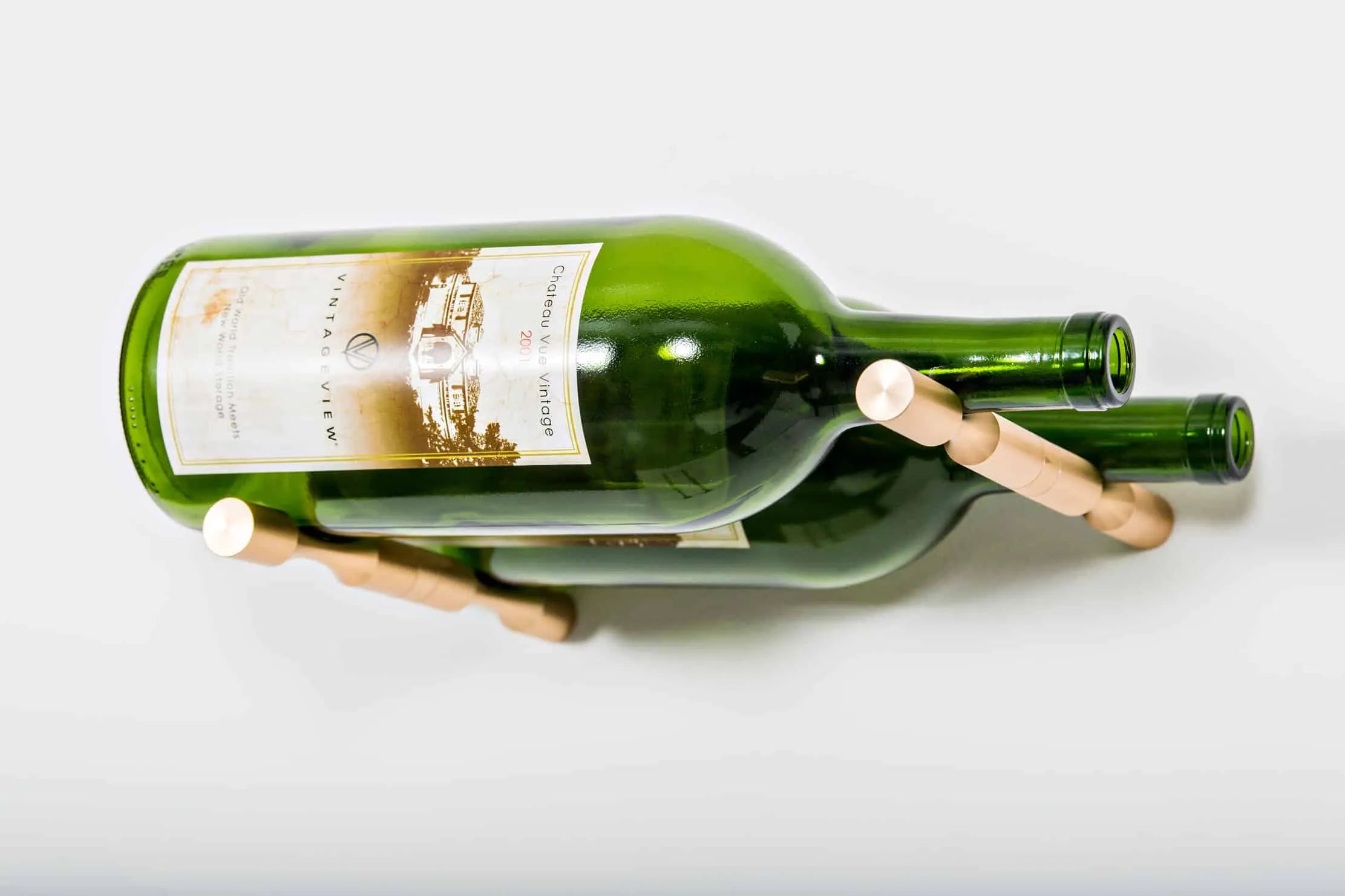 Green wine bottles on a wooden holder against a white background